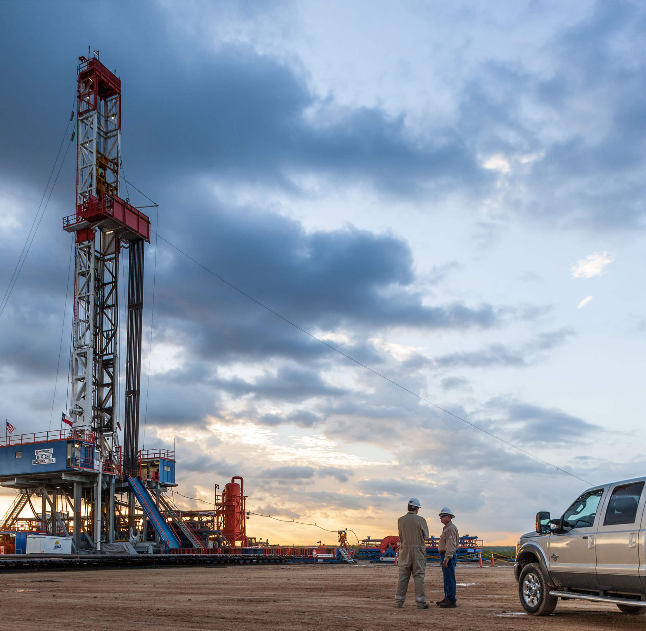 Two workers meeting at a drilling site